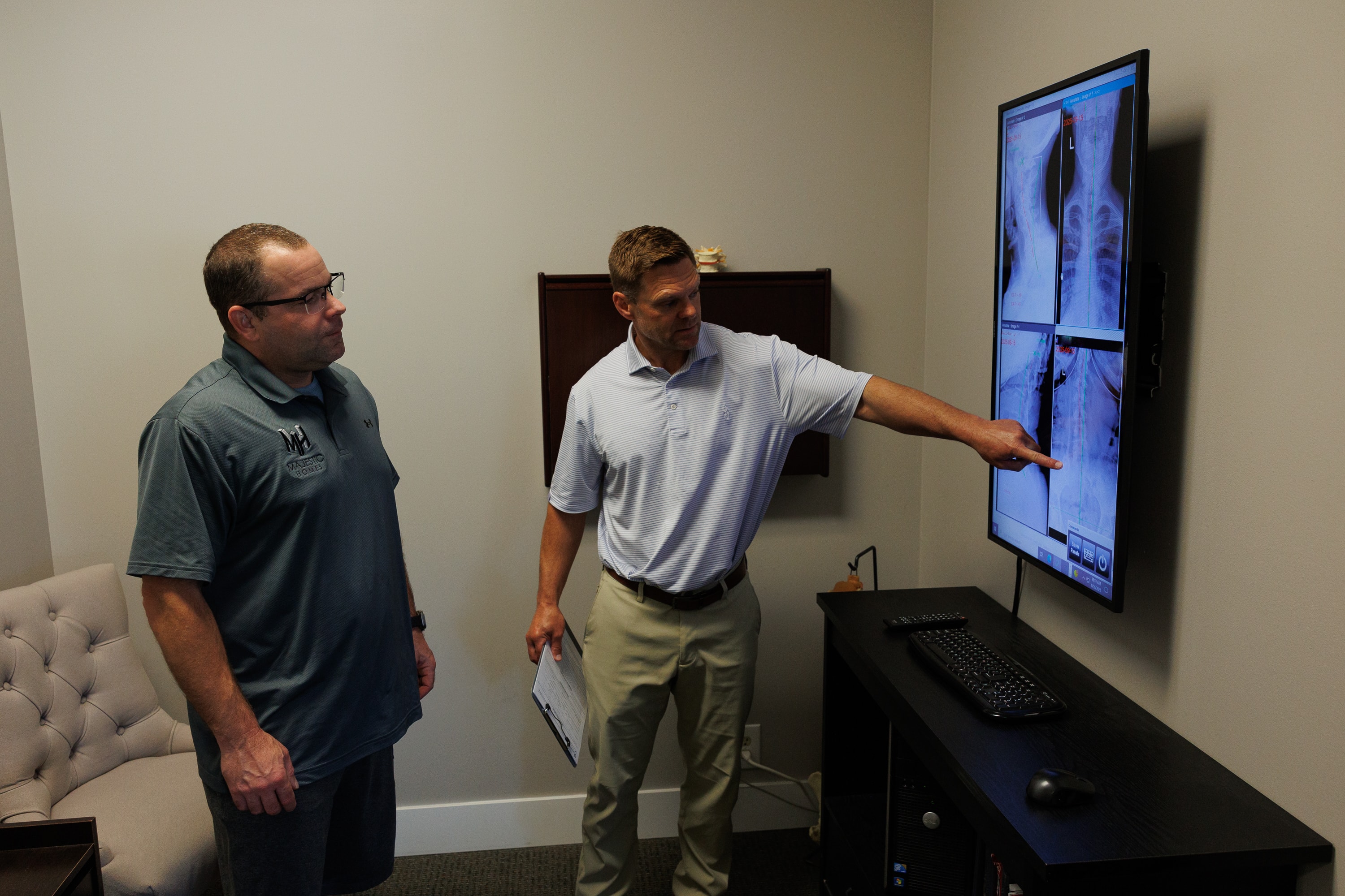 Clinician and patient reviewing spinal X-rays